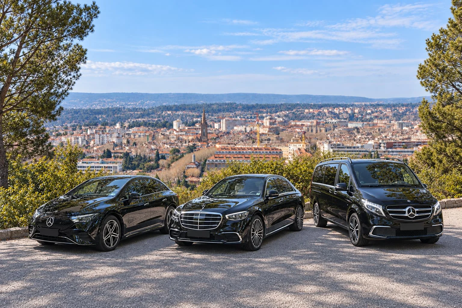 Deux berlines et un van Mercedes noirs devant un panorama urbain.